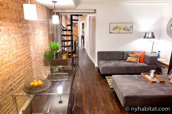 Bild des Wohnzimmers von NY-15192 mit Sofas, Ziegelsteinwänden und einer Wendeltreppe