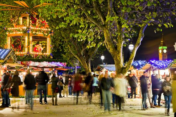 Bild des Weihnachtsmarktes vor dem Tate Modern bei Nacht mit Weihnachtsbeleuchtung und Menschen