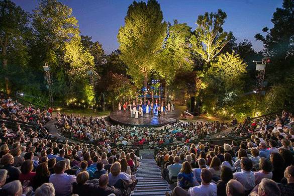 Bild einer Theateraufführung auf einer Bühne im Freien und im Park