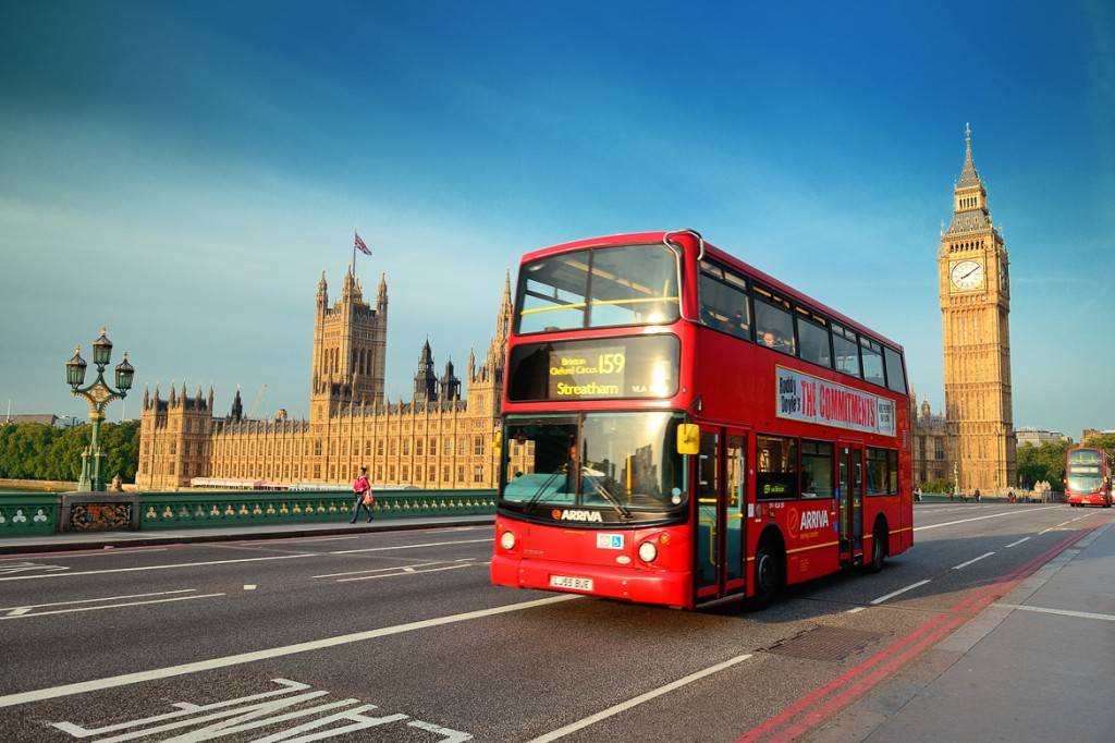 Photo d’un autobus à deux étages circulant devant le Palais de Westminster à Londres