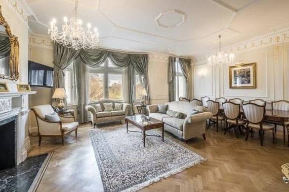 Photo d’un salon comprenant des canapés, du parquet, une télévision à écran plat sur la gauche, une baie vitrée et une table à manger
