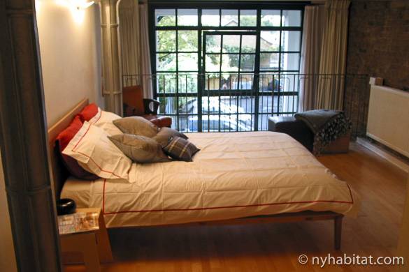 Photo de la chambre de l’appartement LN-824 avec ses portes fenêtres et ses briques apparentes