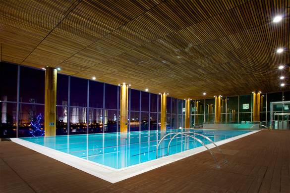 Photographie de la piscine du club de sport London Virgin Active avec la skyline en arrière-plan