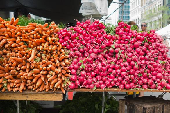 Photo de carottes et de radis sur le stand d’un marché fermier de la ville