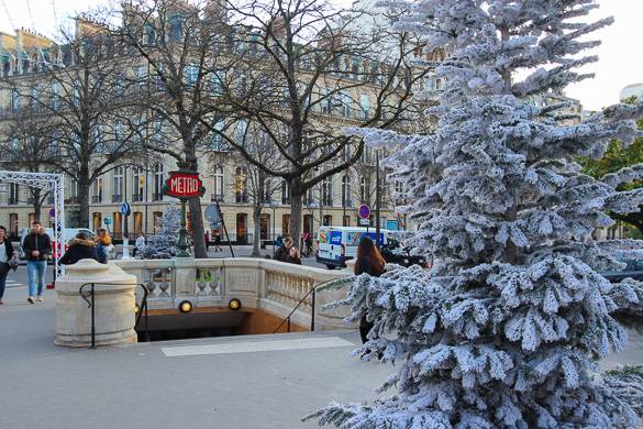 Photo d’un sapin de Noël près d’une bouche du métro parisien