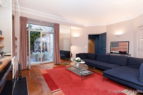 Photo du séjour de l’appartement PA-1754 avec le drapeau américain et la terrasse à l’arrière plan