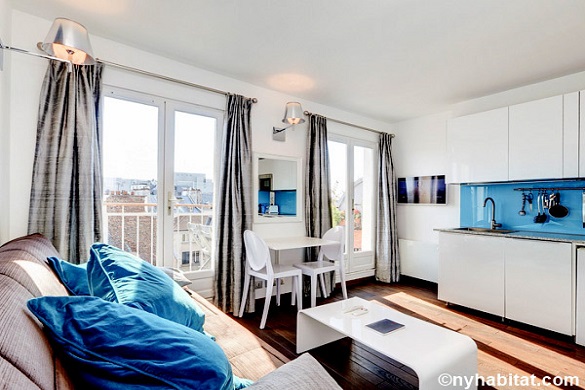 Photo du séjour de l’appartement PA-4565 avec des fenêtres qui donnent sur les toits de Paris