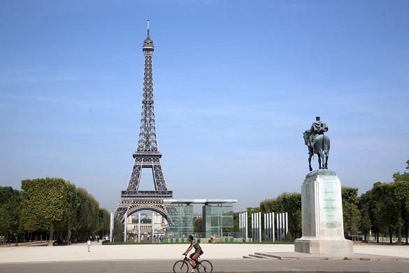 Photo d’une personne qui fait du vélo devant la tour Eiffel à Paris