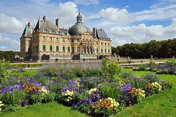 Photo d’un château français baroque avec des jardins colorés