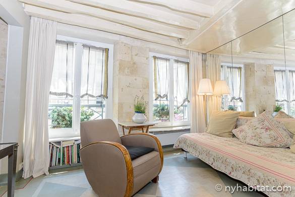Photo du salon blanchi à la chaux de l’appartement PA-3974 avec portes-fenêtres et poutres apparentes en bois blanc