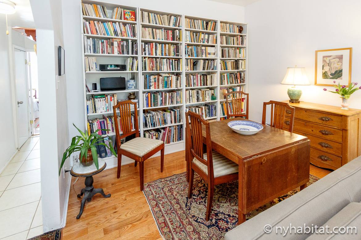 Photo de la table à manger avec à l’arrière des étagères remplies de livres