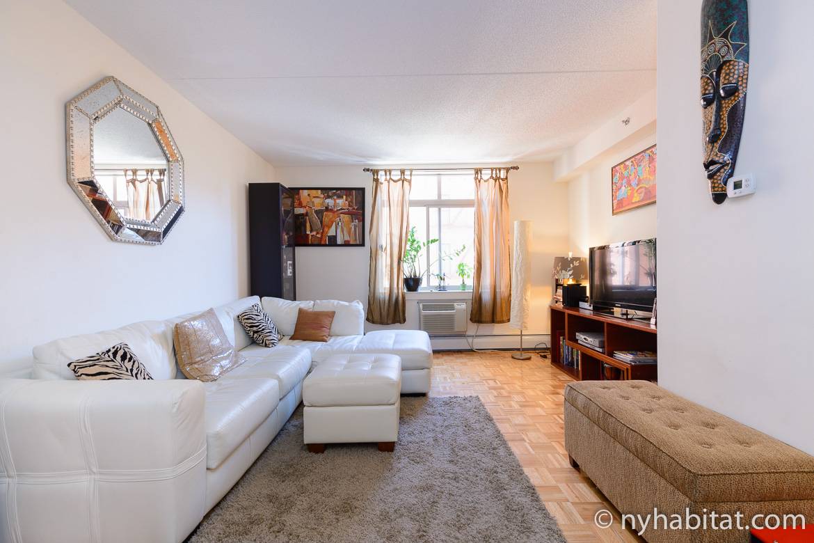 Photo du salon de l’appartement NY-16163 avec un canapé d’angle en cuir blanc et de l'art mural africain