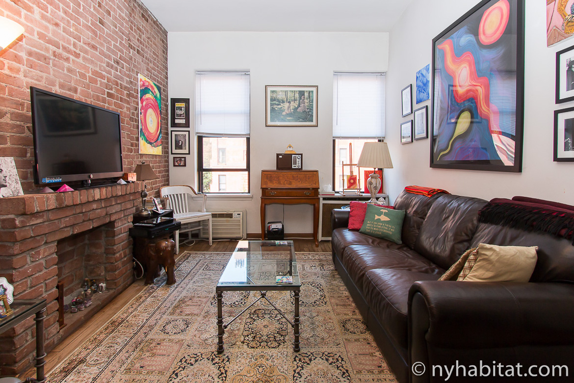 Photo du salon de l’appartement NY-17285 avec un canapé en cuir et des tableaux
