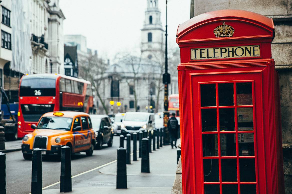 Photo d’une cabine téléphonique londonienne avec un taxi à l’arrière-plan.