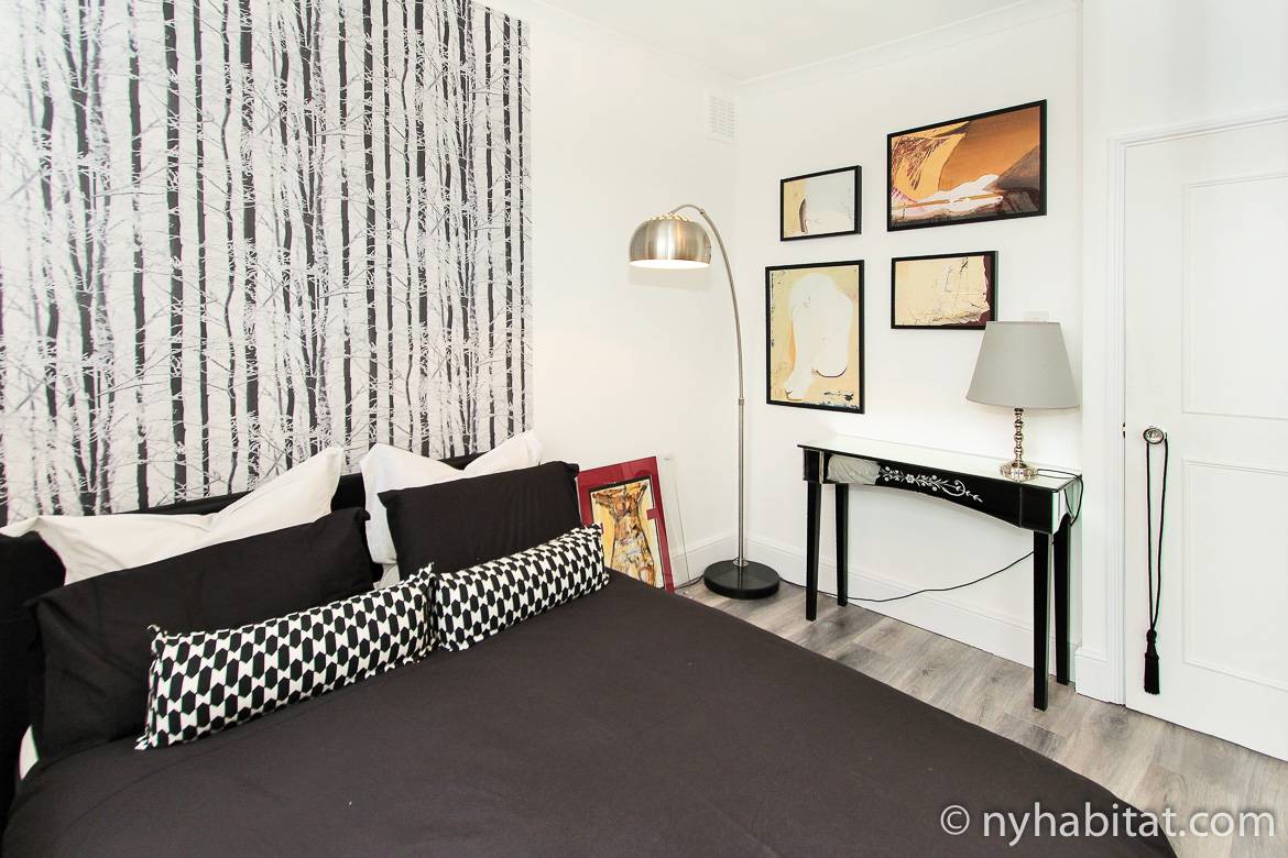 Photo de la chambre du LN-1209 avec lit double, lampe et peintures.