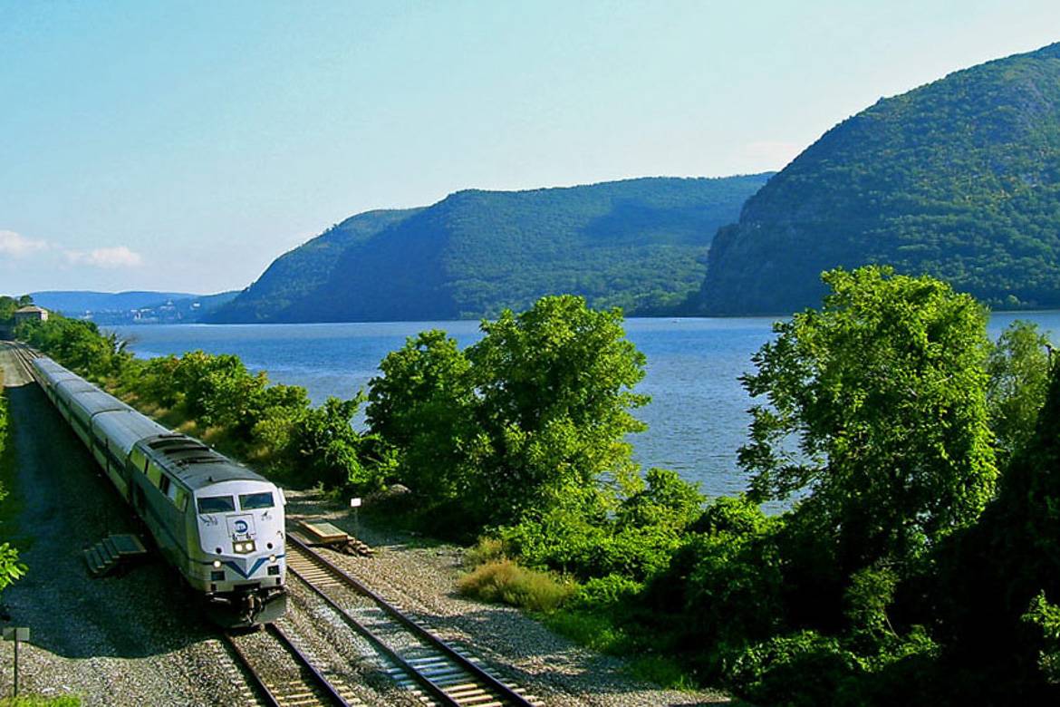 Photo du train MTA Metro North roulant le long du fleuve Hudson et des montagnes.
