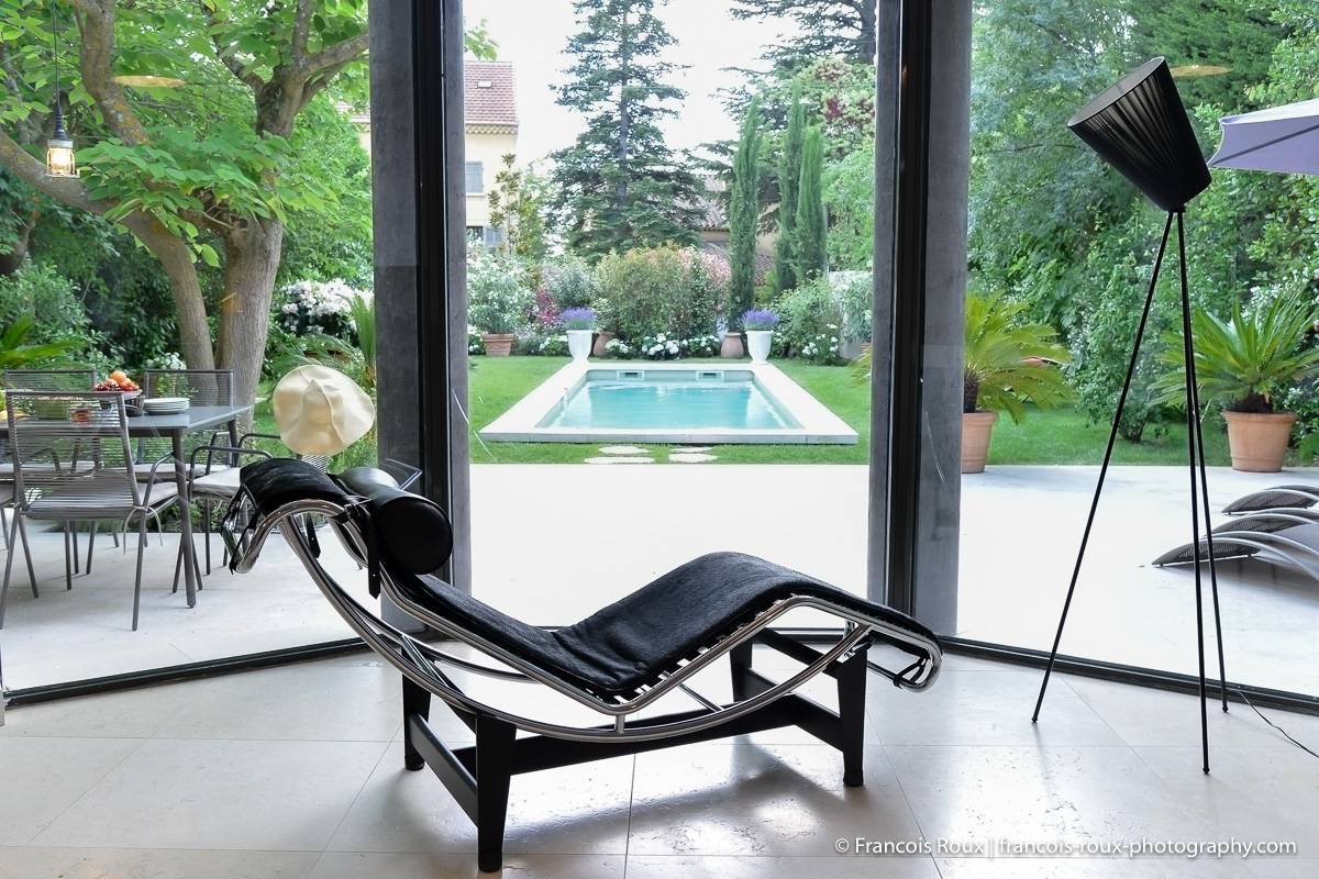 Photo du salon de l’appartement PR-1165 avec une chaise longue, de grandes fenêtres et un jardin.