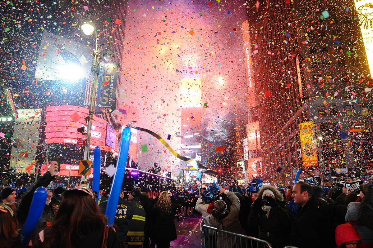 Photo de Times Square avec un feu d’artifice et des confettis lancés après minuit, pour fêter la nouvelle année.