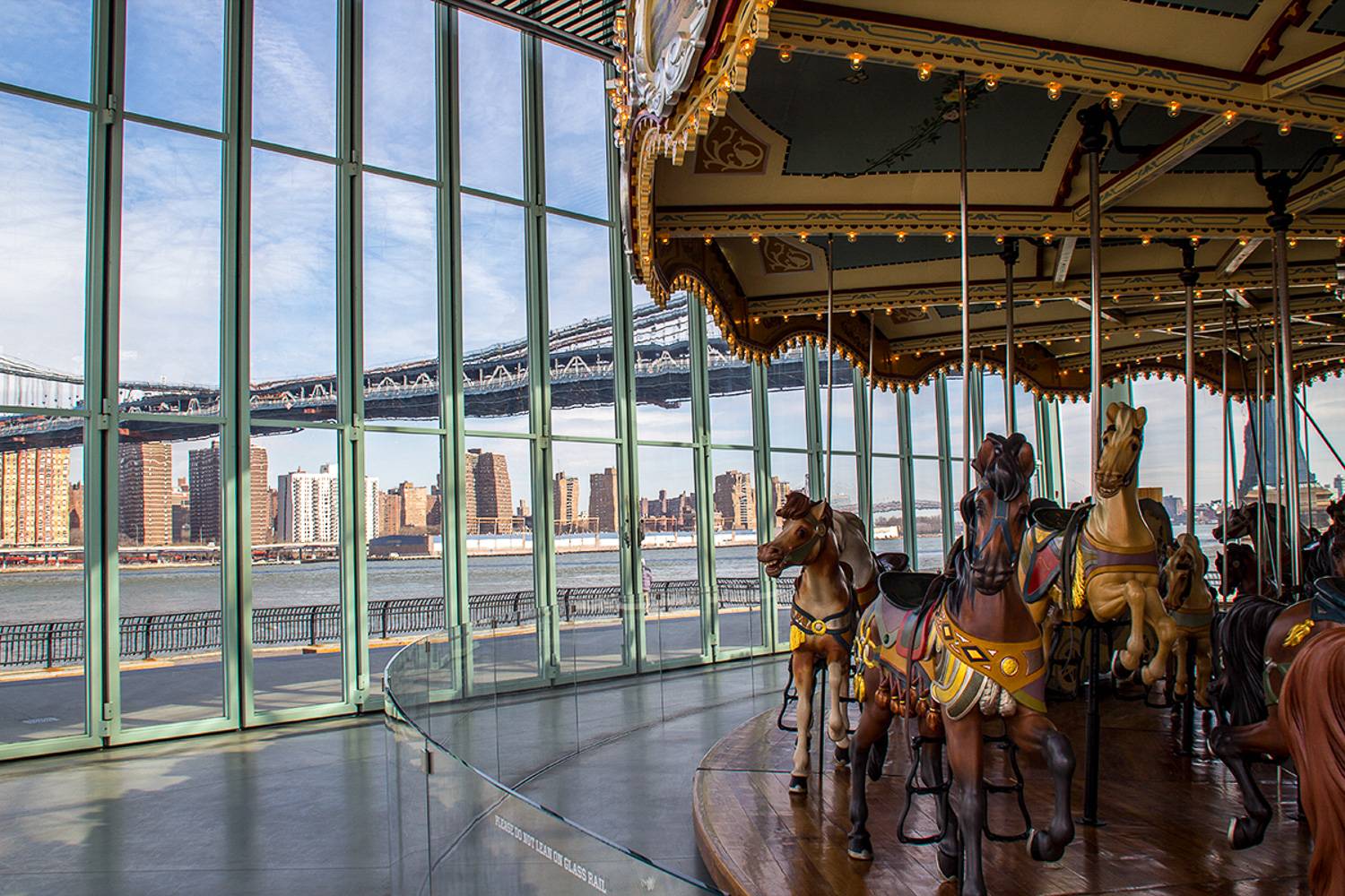 Photo du Jane’s Carousel à Brooklyn avec une vue sur la skyline de New York.
