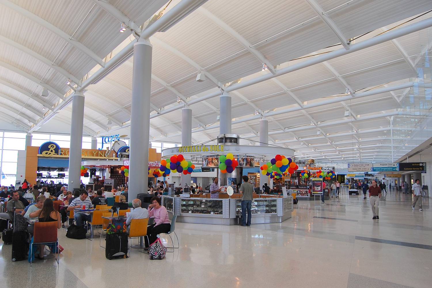 Photo de voyageurs assis à des tables de restaurants dans l’un des terminaux de l’aéroport international de Newark-Liberty.