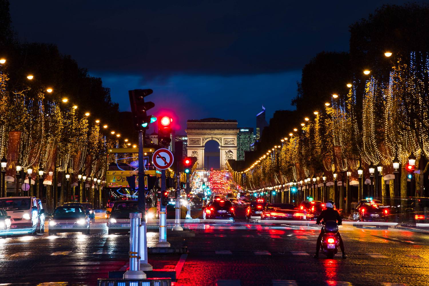 Photo des Champs-Élysées avec des illuminations de Noël sur les arbres.