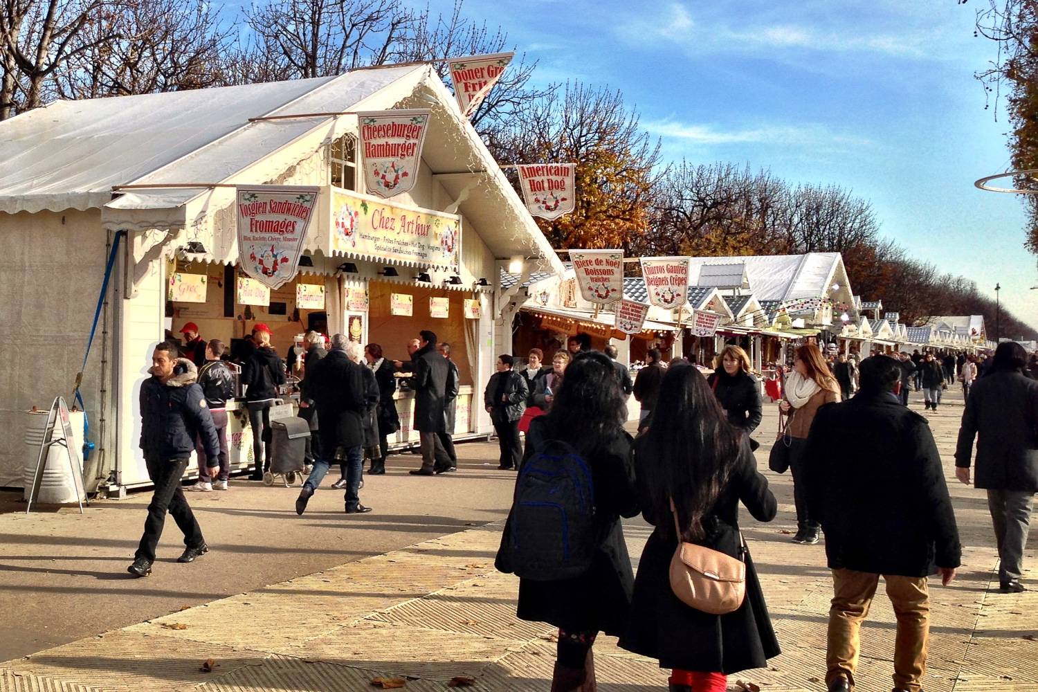 Photo du marché de Noël des Champs-Élysées avec des stands de nourriture et des boutiques.