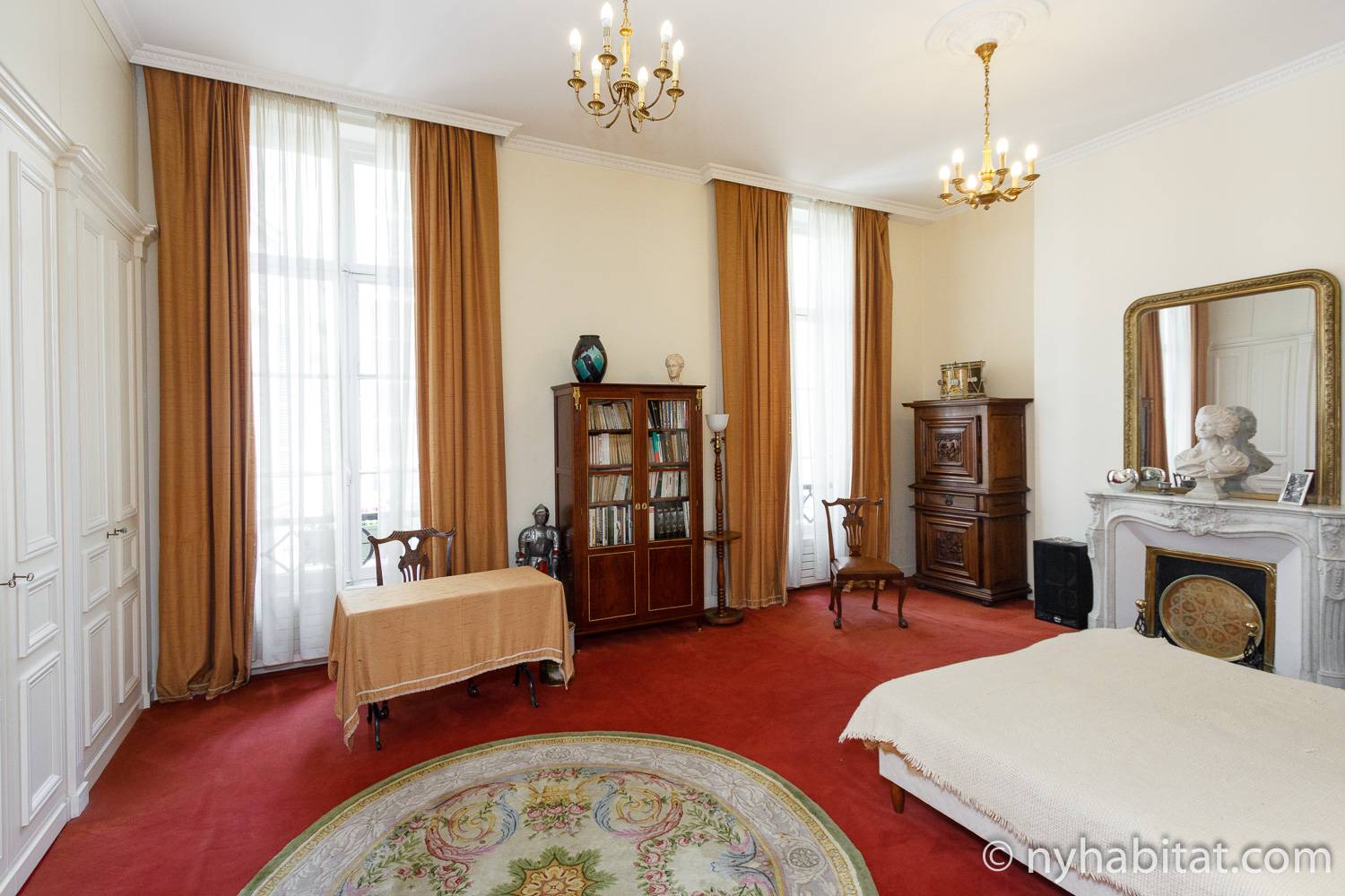 Photo de la chambre de l’appartement PA-3231 avec cheminée décorative, penderie et lustres.