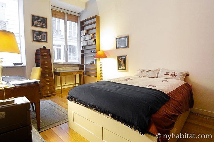 Photo d’une chambre de l’appartement PA-4187 avec lit double, bureau et étagères.