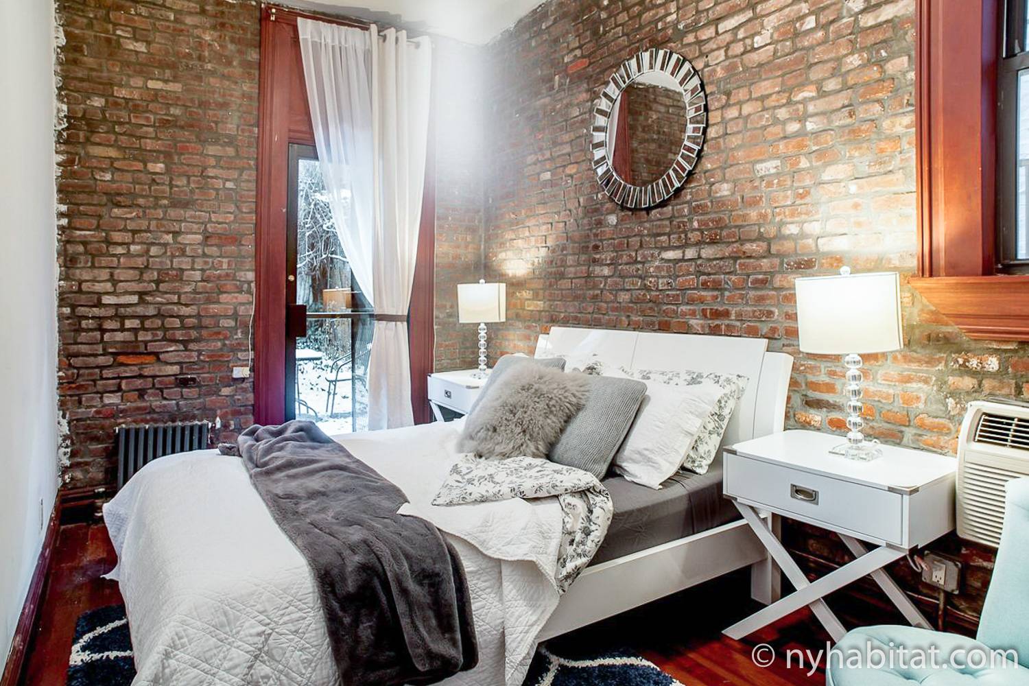 Photo de la chambre du NY-16546 avec lit queen-size, miroir et porte donnant sur la terrasse