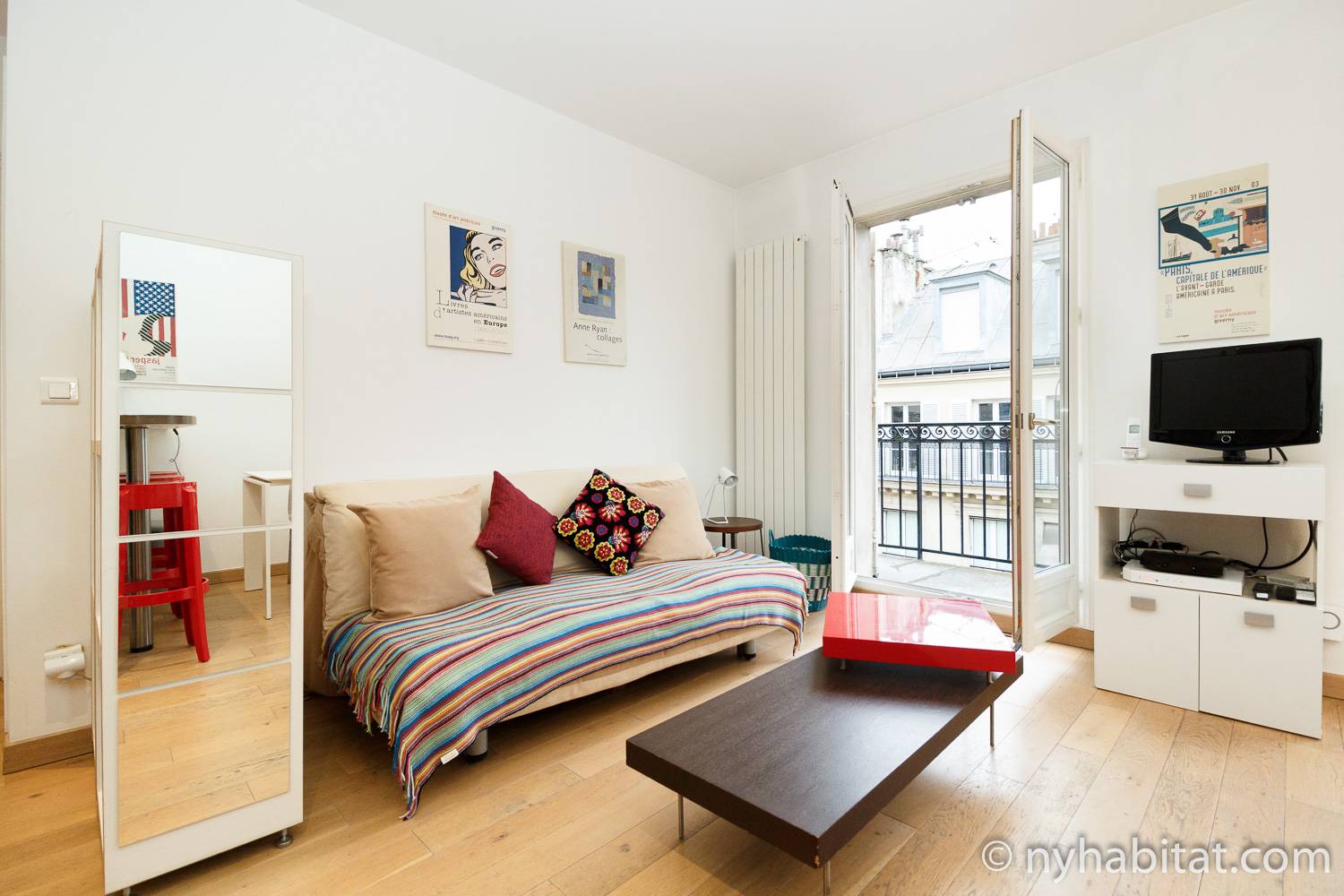 Photo de la pièce à vivre de l’appartement PA-3311 avec un canapé et une porte donnant sur le balcon.