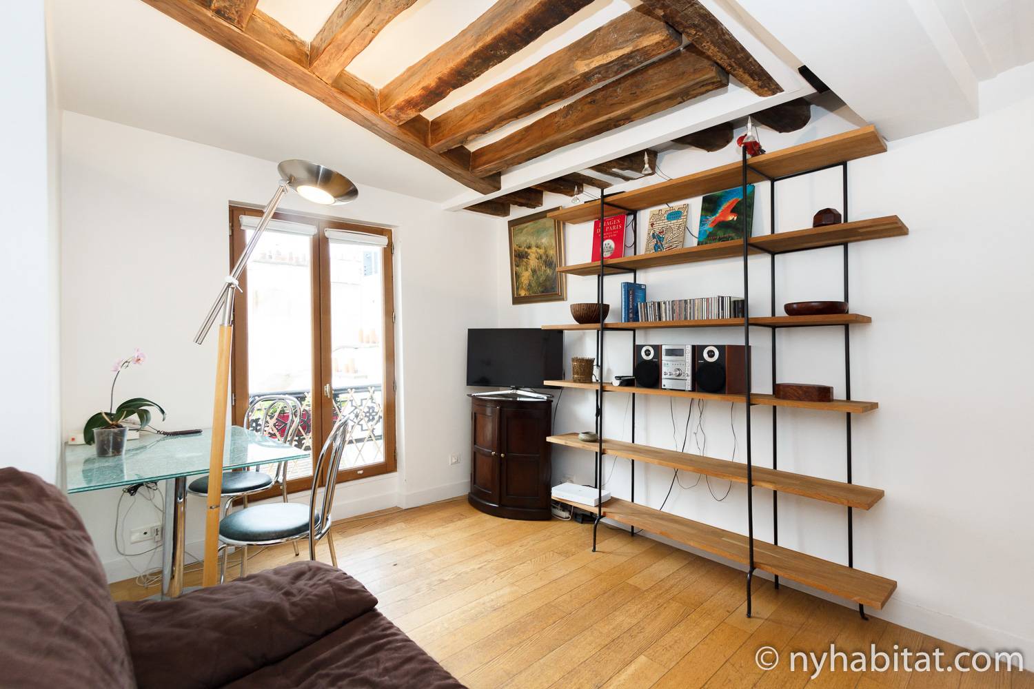 Photo de la salle à manger de l’appartement PA-3675 avec canapé, table et chaises, et bibliothèque.