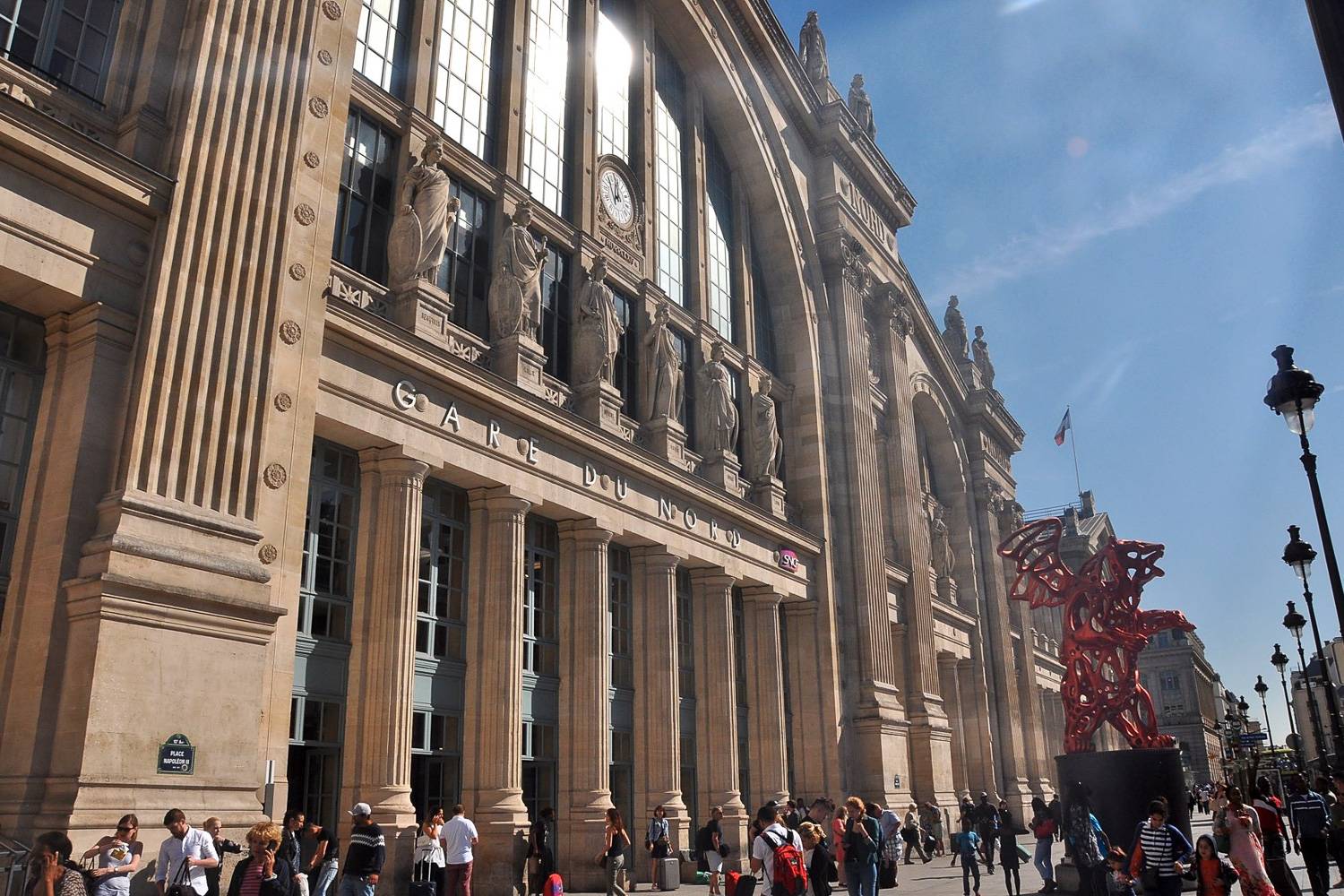 Photographie de la façade de la gare du Nord avec des piétons.
