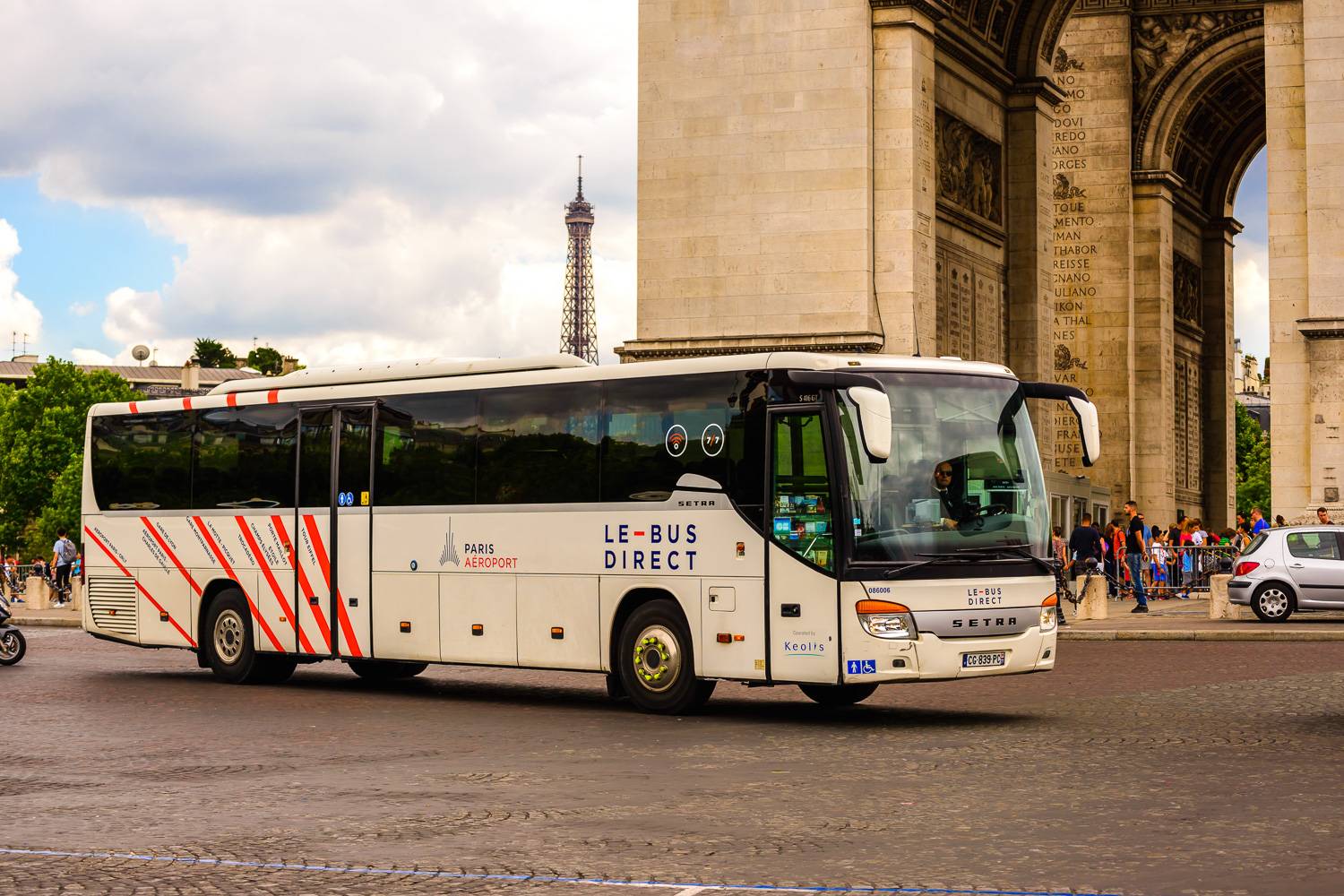 Photographie du Bus Direct sur le départ devant l’Arc de Triomphe à Paris.