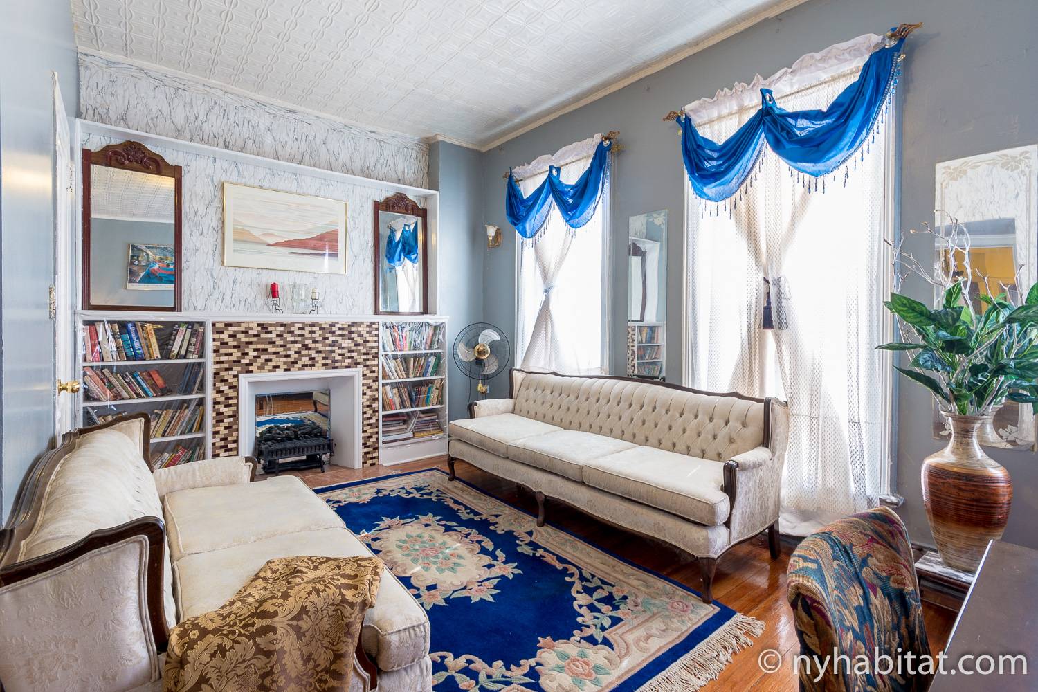 Photo du salon de la location de vacances NY-15544 avec des canapés à l’ancienne autour d’une cheminée