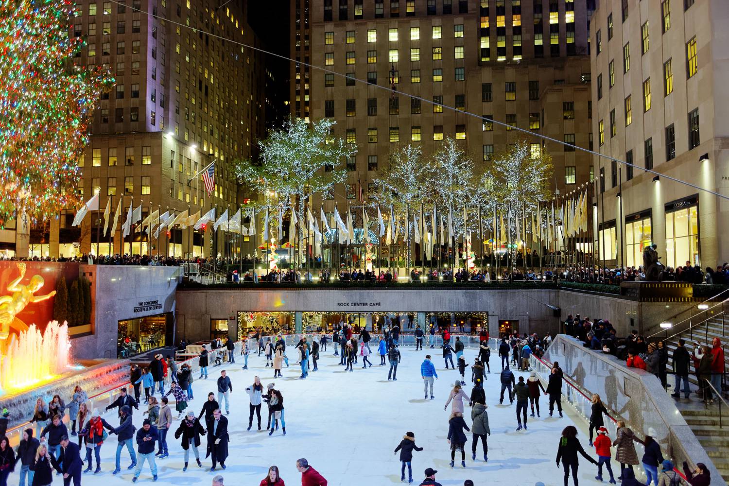 Photo de personnes patinant la nuit devant le célèbre sapin de Noël du Rockefeller Center