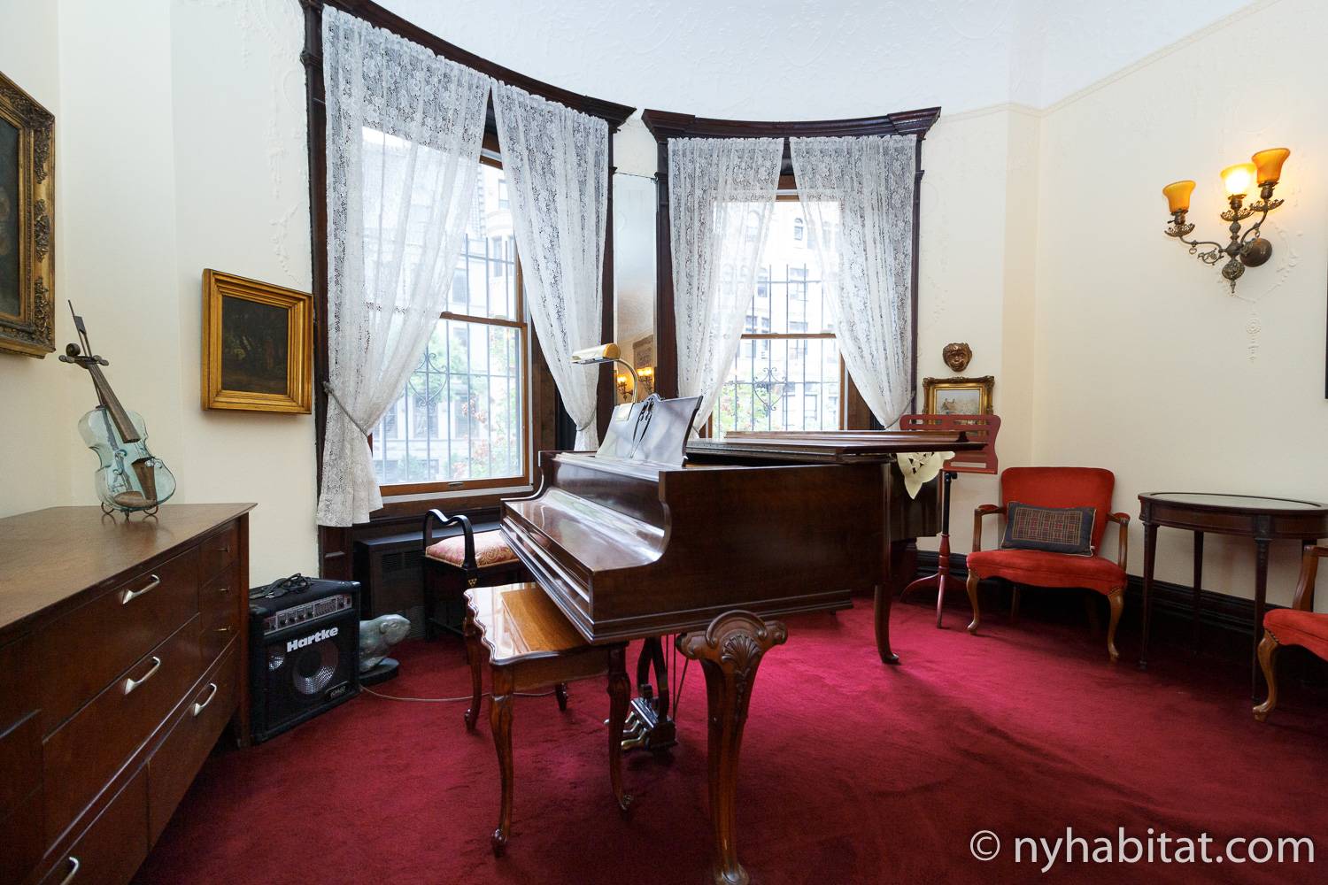 Photo d’un piano dans le salon du NY-14656 avec moquette rouge et meubles anciens