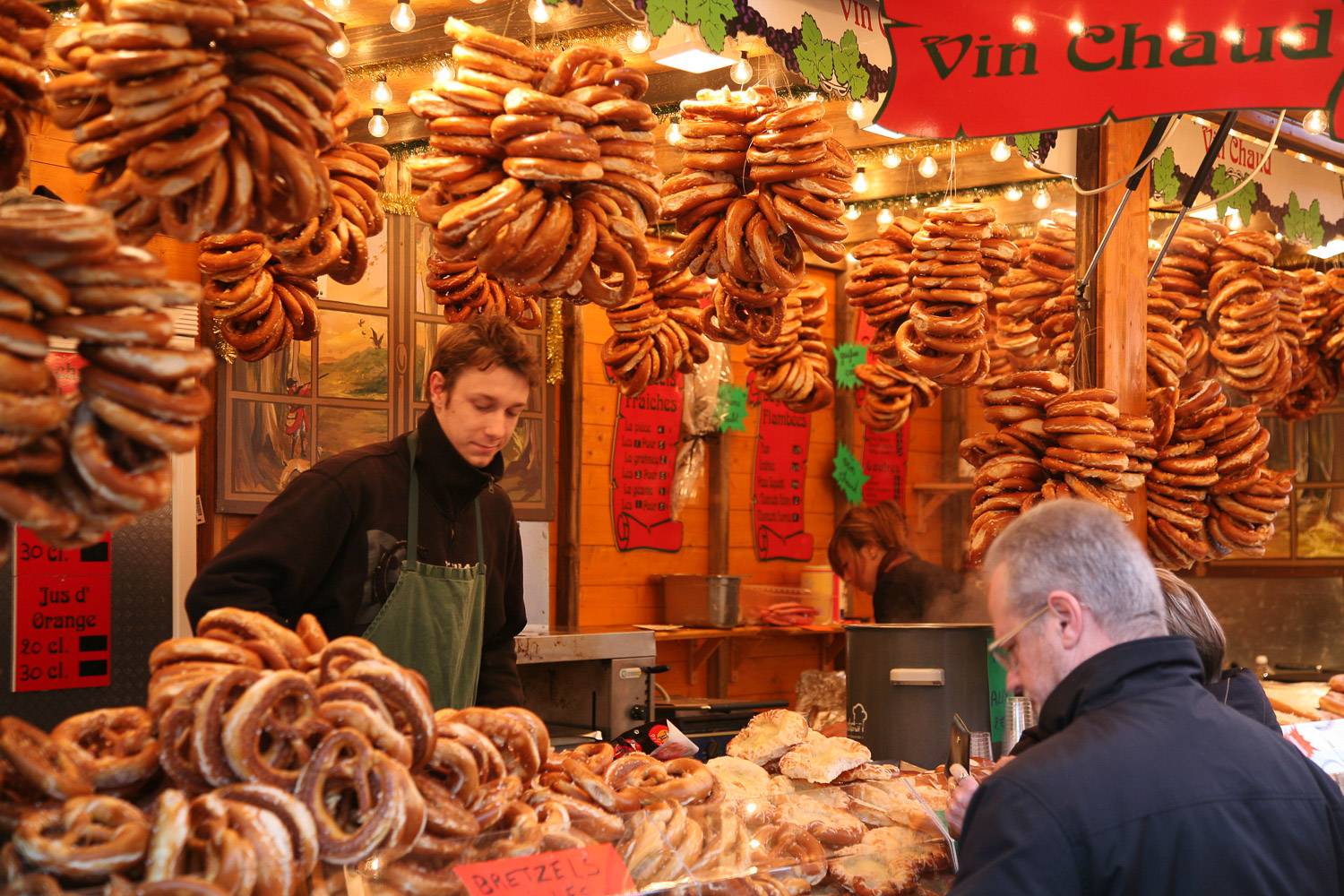Photo d’un stand vendant des bretzels et du vin chaud. Les bretzels sont montrés suspendus autour d’un stand.