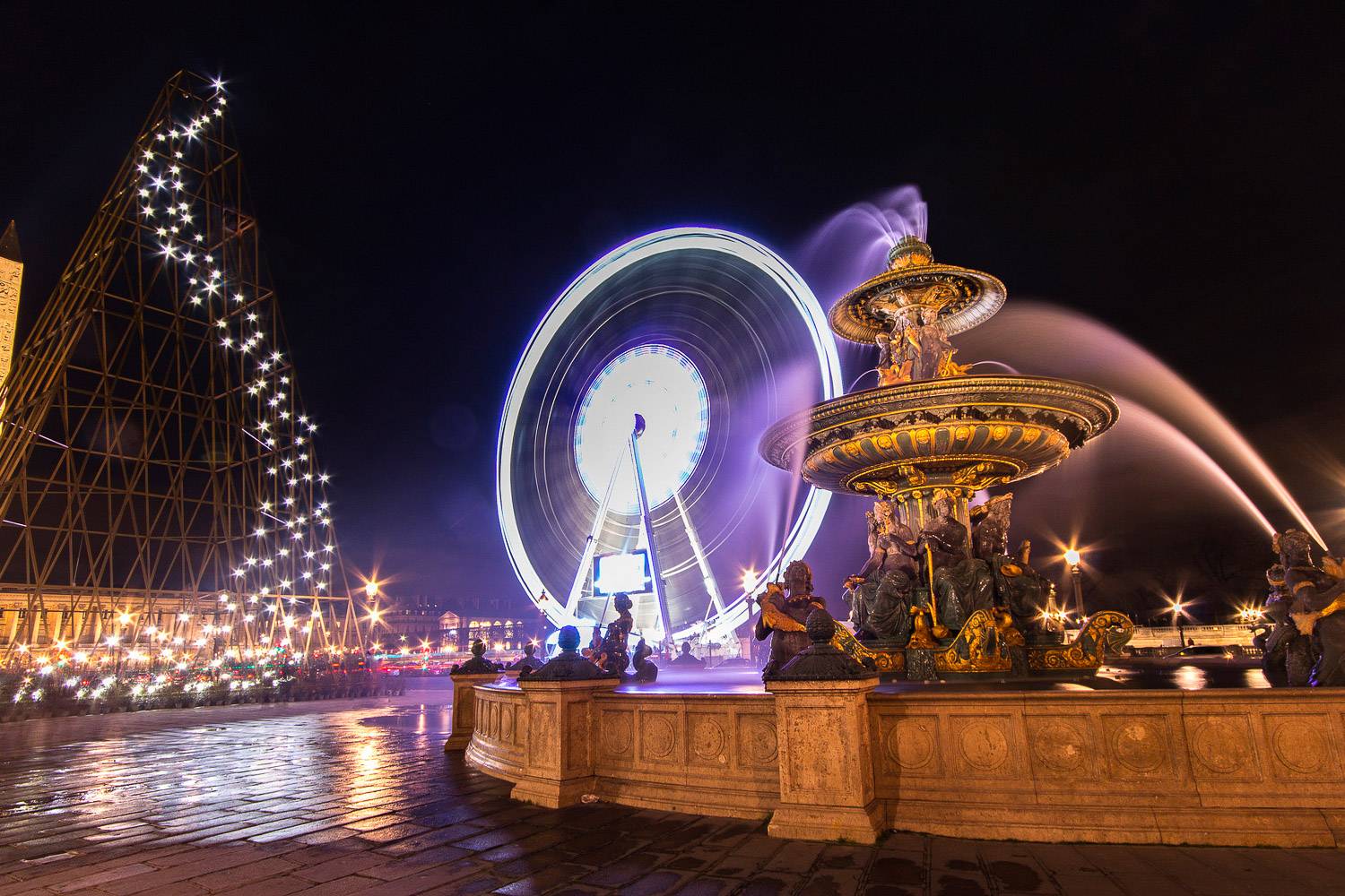 Photo de la place de la Concorde avec une grande roue, une fontaine et un sapin de Noël en pleine installation.