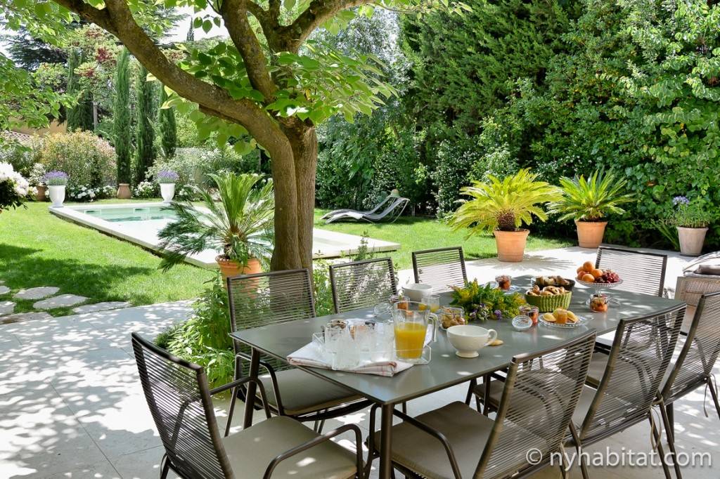 Immagine di un tavolo da pranzo imbandito vicino alla piscina all’esterno della Villa Cézanne