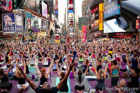 Foto di un gruppo di persone che fanno yoga a Times Square