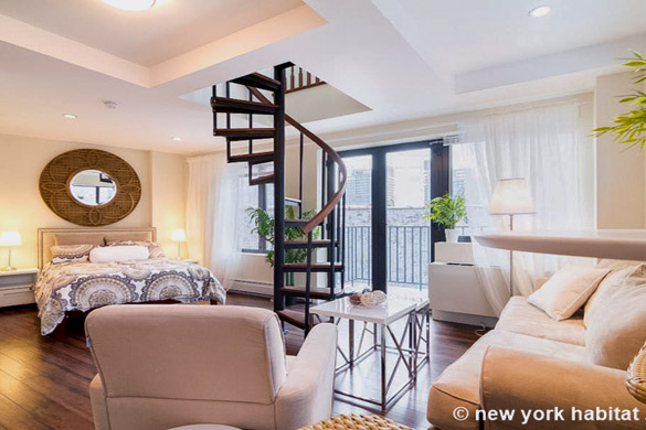 immagine dell’area relax e scala a chiocciola di NY-16334, con uno specchio rotondo sullo sfondo