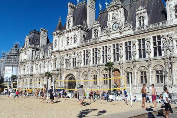 Immagine di alcune persone che giocano a beach volley di fronte all’Hôtel de Ville
