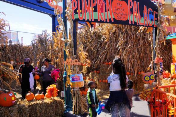 Immagine di bambini in un area piena di fieno e di zucche nel Luna Park a Coney Island