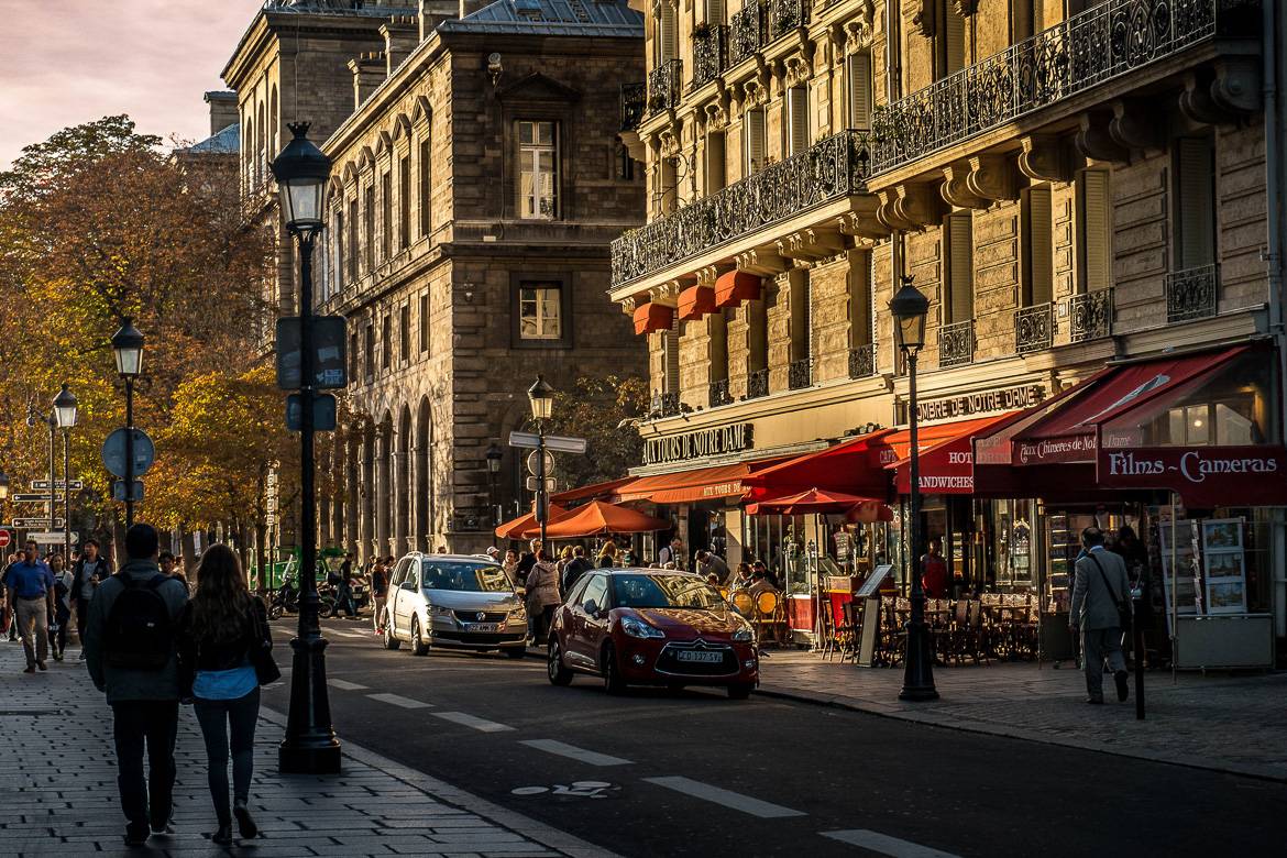 Immagine di persone che camminano lungo Rue du Cloitre al tramonto