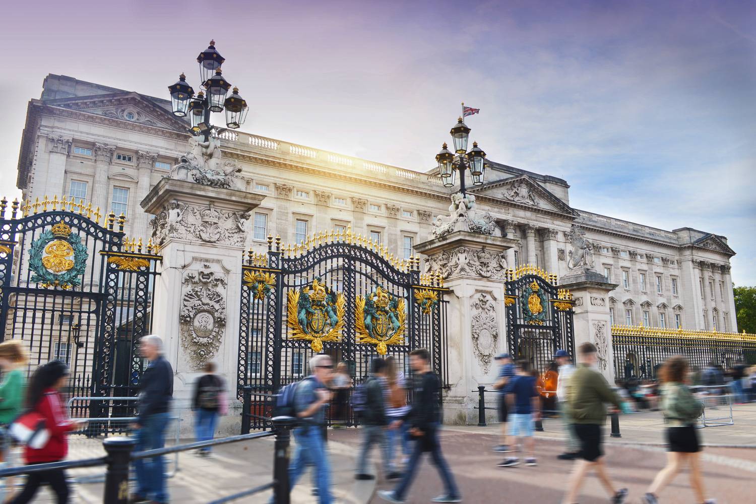 Un’immagine di Buckingham Palace mentre locali e turisti passeggiano per la città.