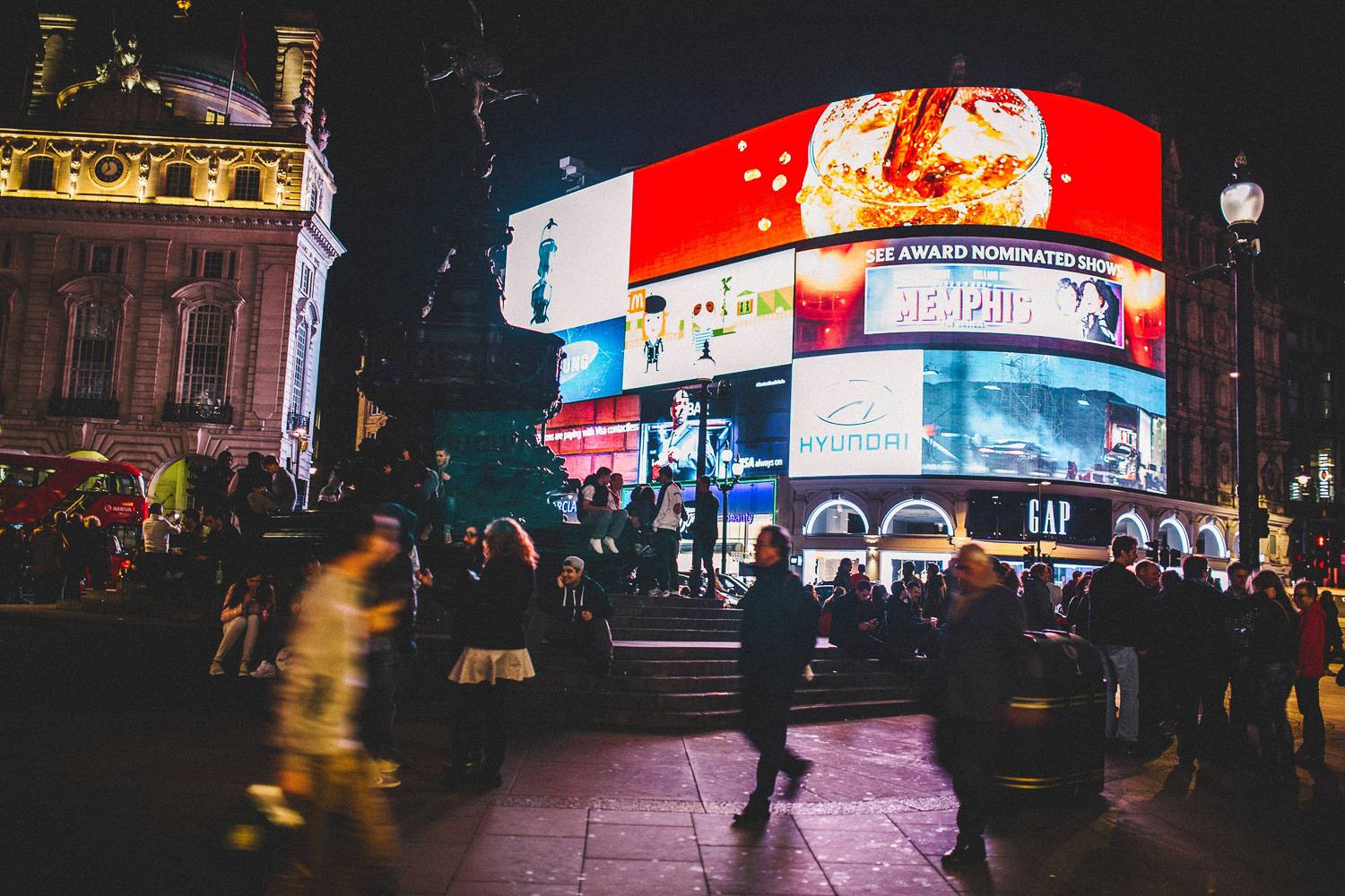 Una foto dei luminosi cartelloni pubblicitari al neon e delle strade animate di Piccadilly Circus.