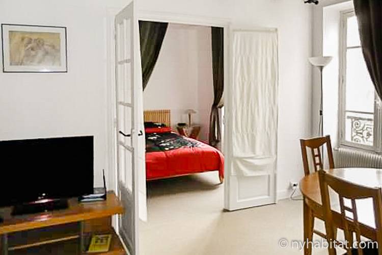 Vista sulla camera da letto dal soggiorno nell’appartamento PA-2597 con porte finestra che dividono le stanze.