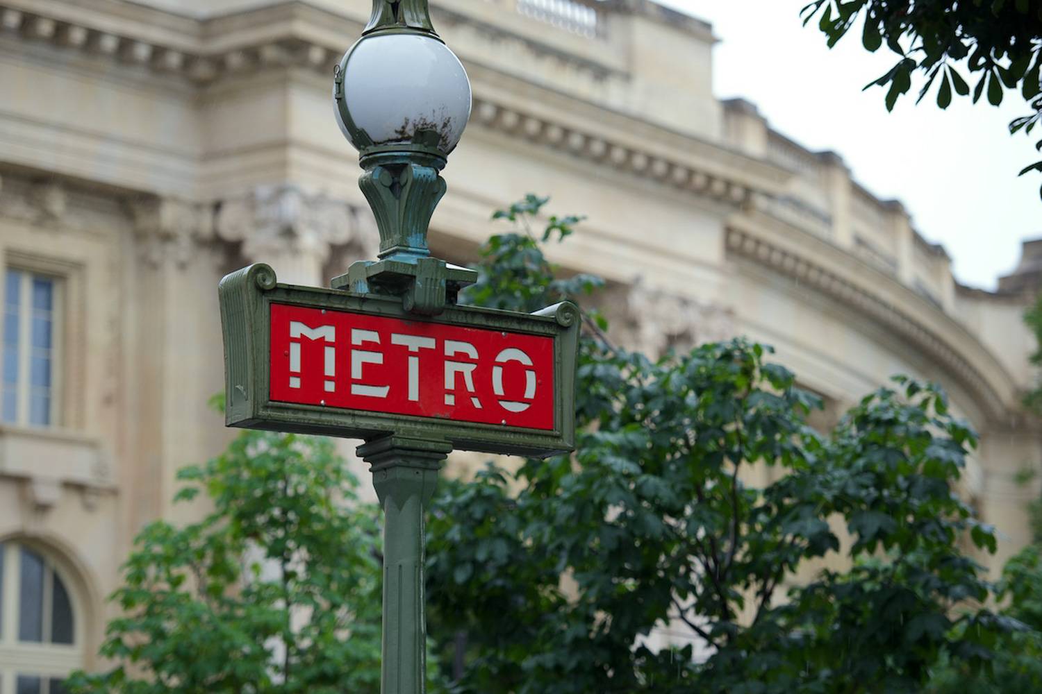 Immagine del segnale rosso della Métro davanti a un palazzo di Parigi.