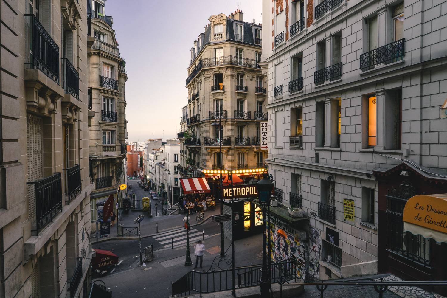 Immagine di una via di Parigi dalla cima di una scalinata al tramonto.