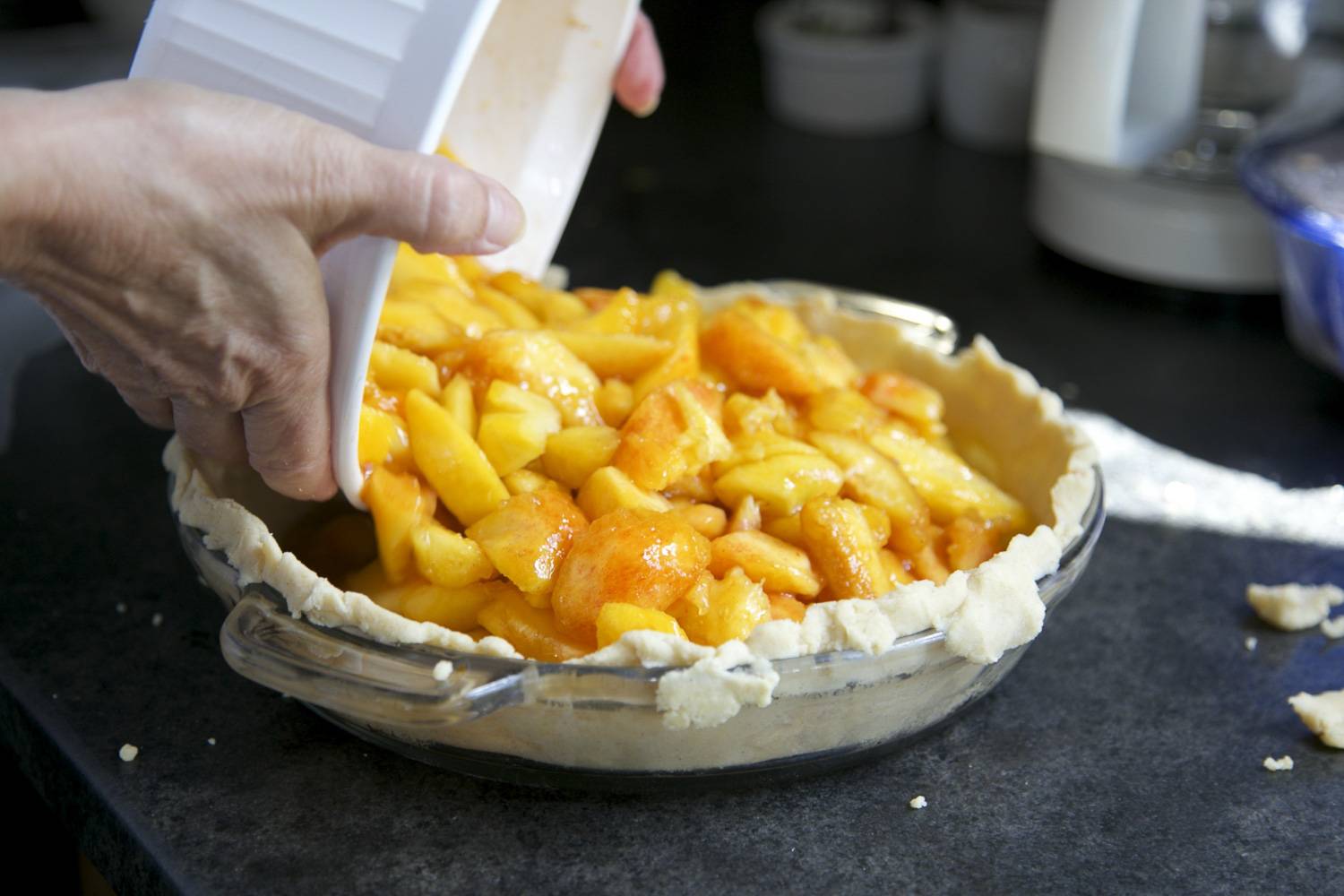 Immagine di pasta frolla che viene farcita con mele in un piatto di mele.